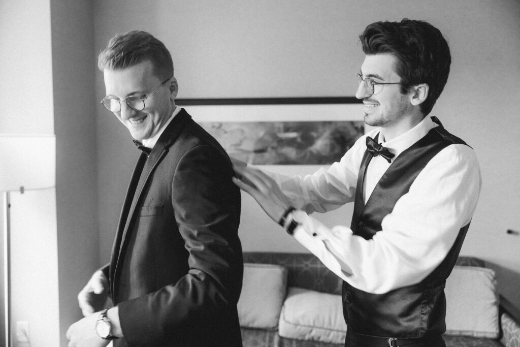 Best man adjusting the groom’s tie in a candid moment at Embassy Suites Pittsburgh Downtown.