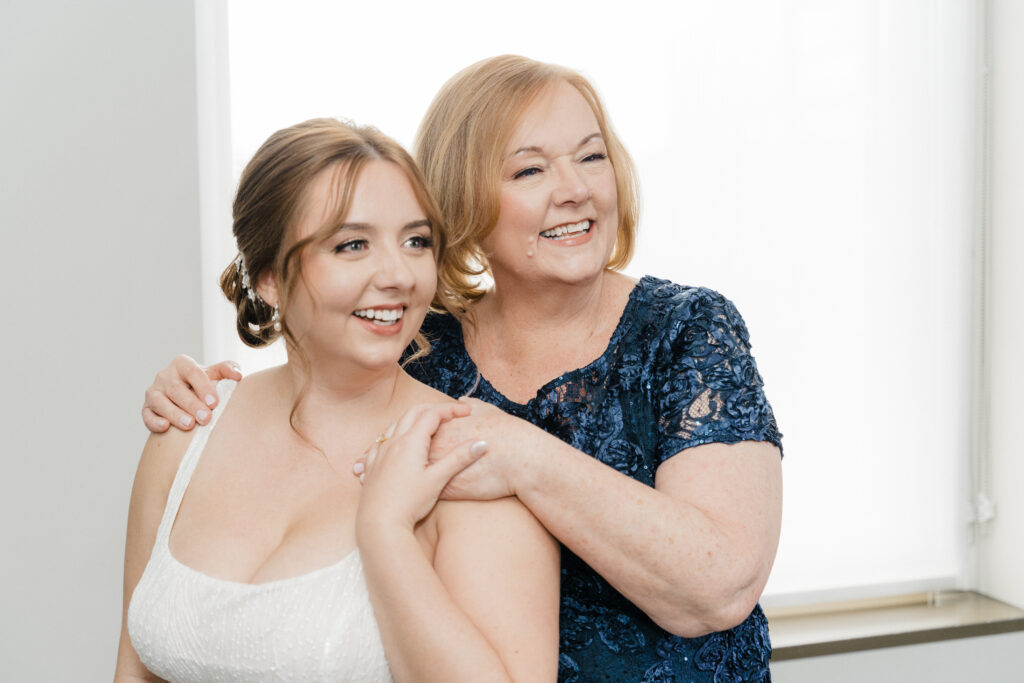 Candid moment of the bride and her mom smiling while getting ready at Embassy Suites Pittsburgh