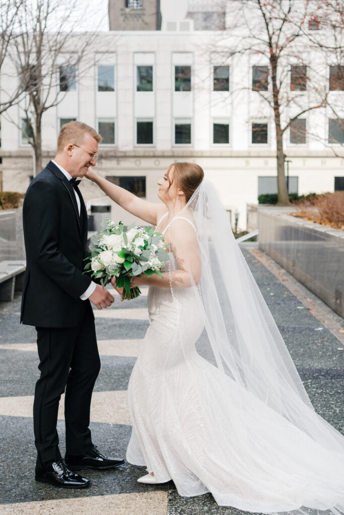 Bride and groom embracing during an emotional first look as the groom cries at Embassy Suites Pittsburgh Downtown.