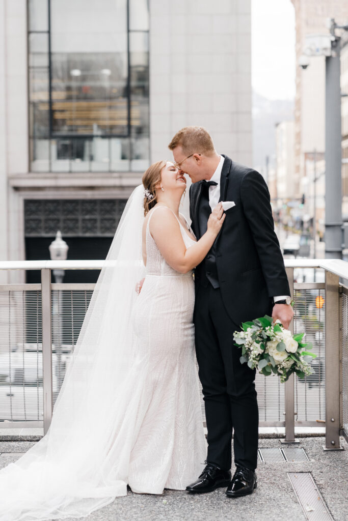 Candid moment of the couple walking hand in hand on a bridge in downtown Pittsburgh.