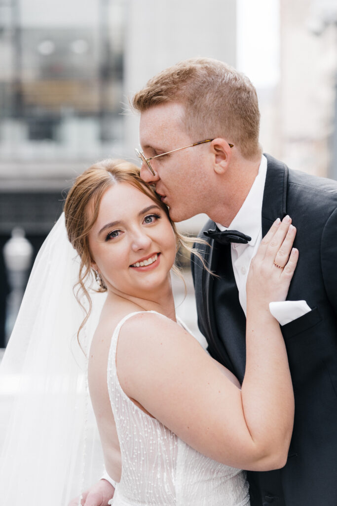 Bride and groom posing with the Pittsburgh skyline as a romantic backdrop