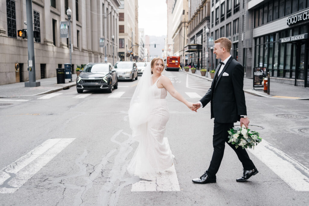 Wedding couple embracing with the city of Pittsburgh’s iconic architecture in the background.