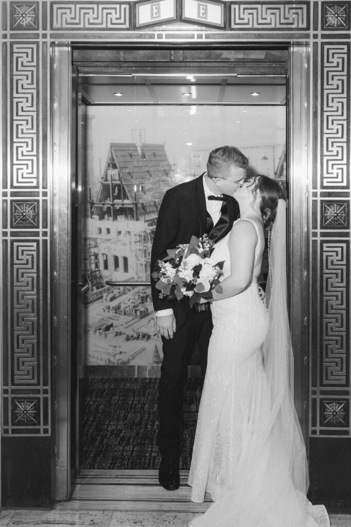 Fun moment of the couple posing playfully inside an elevator with flash photography at Embassy Suites Pittsburgh.