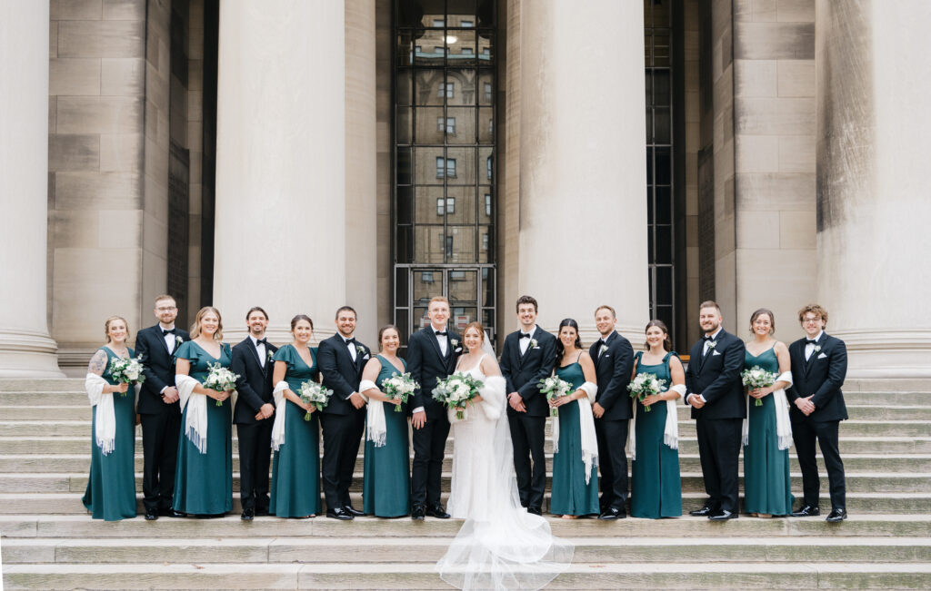 Full bridal party gathered around the bride and groom, smiling and celebrating together at Embassy Suites Pittsburgh Downtown.