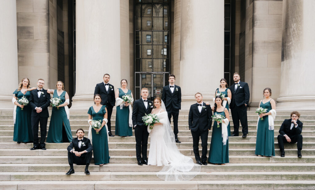 Bridal party striking a chic vogue-inspired pose in front of the Mellon Institute Columns.