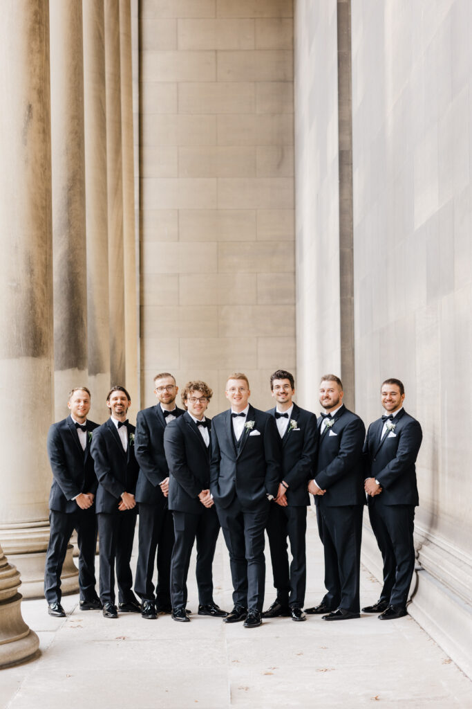 Groomsmen posing stylishly in front of the Mellon Institute Columns during the wedding day.