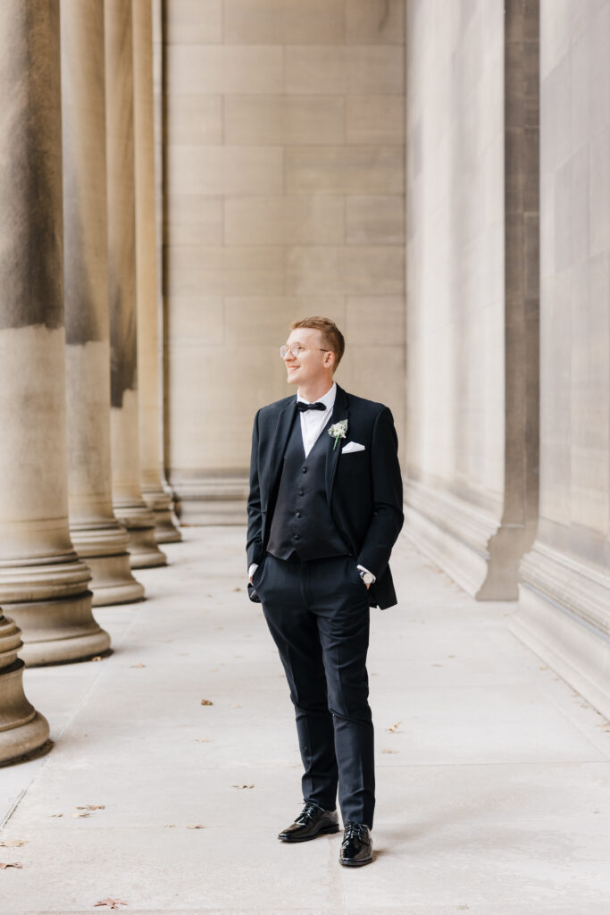 Groom standing confidently in front of the Mellon Institute Columns during the wedding day.