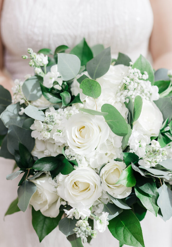 bride holding bouquet of white roses