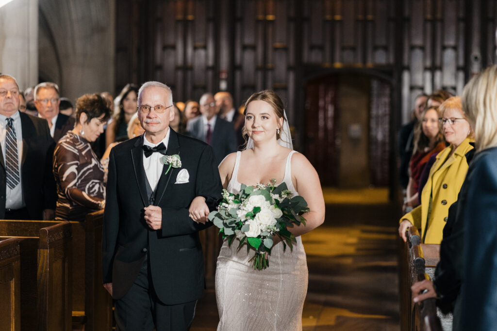 Bride walking down the aisle with her dad during the ceremony at Heinz Chapel.