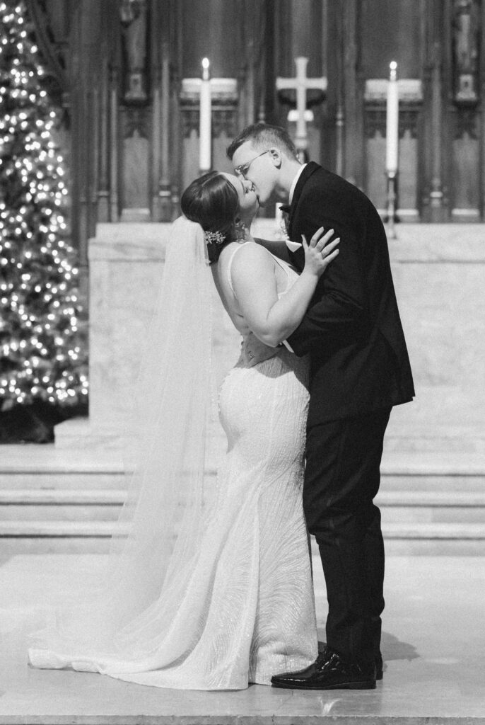 Bride and groom sharing their first kiss at the altar during the ceremony at Heinz Chapel.