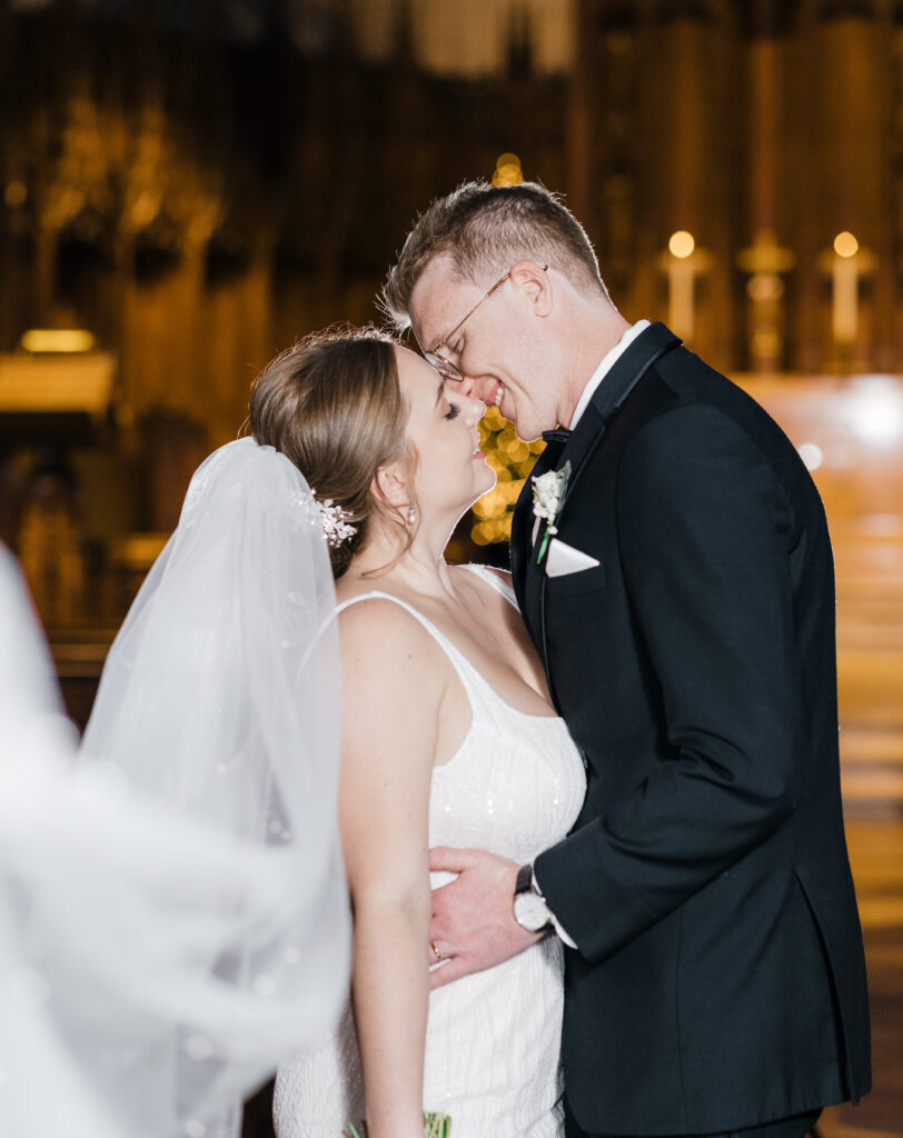 Bride and groom sharing a romantic kiss in the middle of Heinz Chapel, captured in vibrant color.