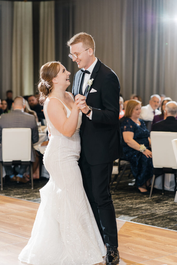 Candid moment of the couple smiling while dancing during their first dance at Embassy Suites Pittsburgh.