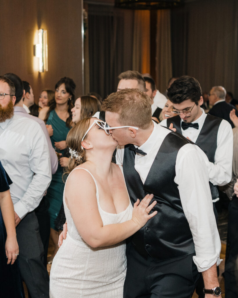 Bride and groom sharing a romantic kiss in the middle of the dance floor at Embassy Suites Pittsburgh Downtown.